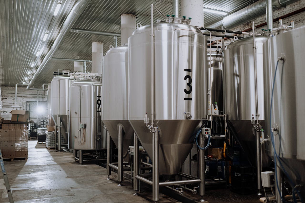 Interior view of a modern brewery showcasing stainless steel fermentation tanks.